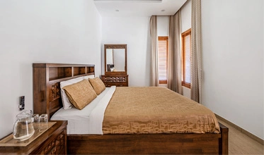 Cozy Maple Room at Punya Farms offering a peaceful stay near Isha Yoga Center.