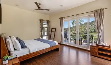 Ground floor bedroom with scenic lake view at Kalpavriksha Villa.
